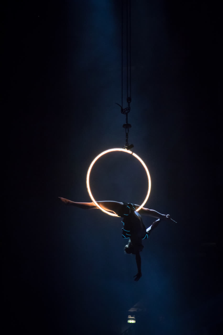 An aerial performer silhouetted inside an illuminated ring
