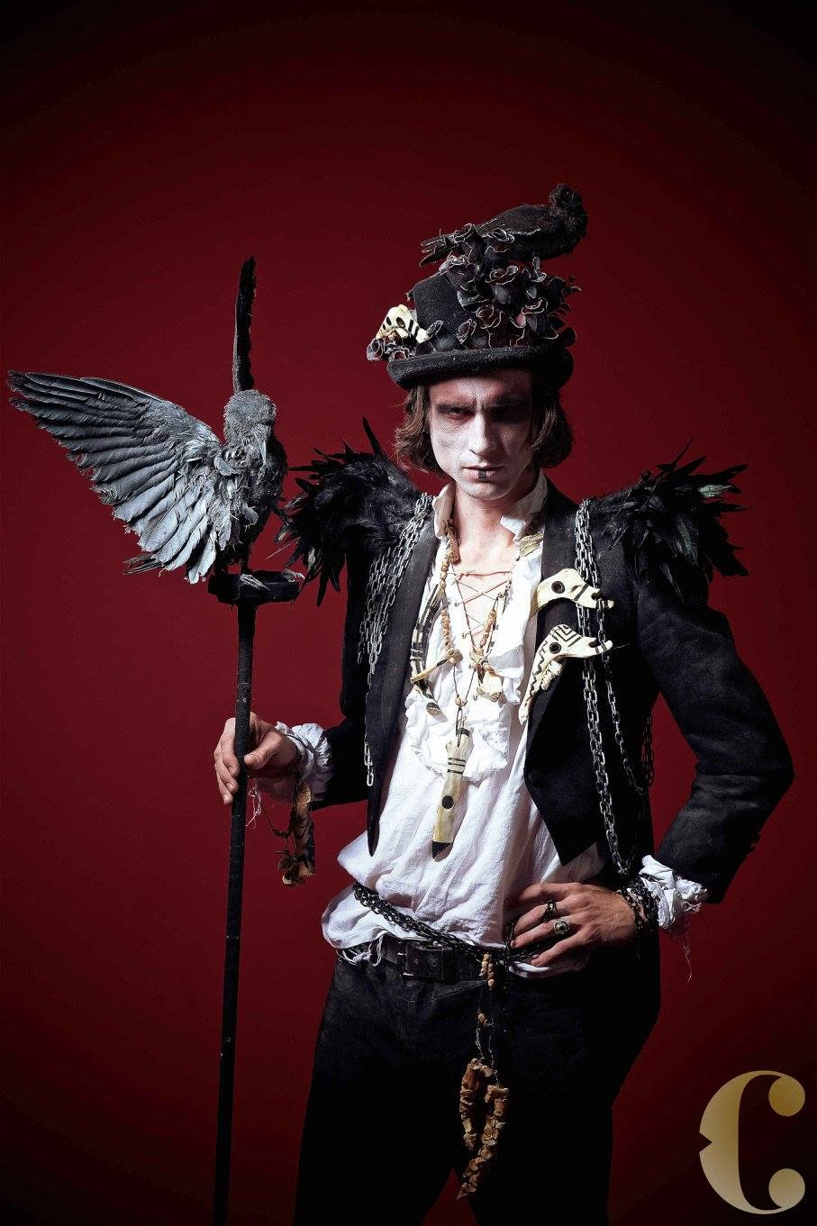 A performer in an ornate winged costume with a staff